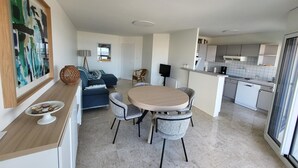 A modern apartment with a dining area, kitchen, and living space.