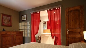 A bedroom with a bed, a dresser, a mirror, and a door. - Charming house with garden and parking in Val-Saint-Père (Le Val-Saint-Père)