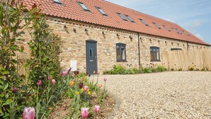 A brick building with a red-tiled roof, multiple windows, and a gravel driveway. - Wild Cherry Barn, Ashlin Farm Barns (Lincoln)