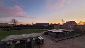 A backyard with a barbecue area, a picnic table, and a brick wall. - Wild Cherry Barn, Ashlin Farm Barns (Lincoln)