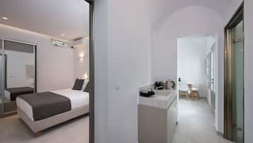 Une chambre d’hôtel moderne équipée d’un lit, d’une petite kitchenette et d’une salle de bain.