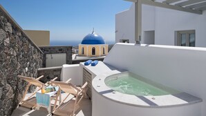 Une terrasse sur le toit avec un jacuzzi, des chaises longues et une vue sur un bâtiment à coupole bleue.