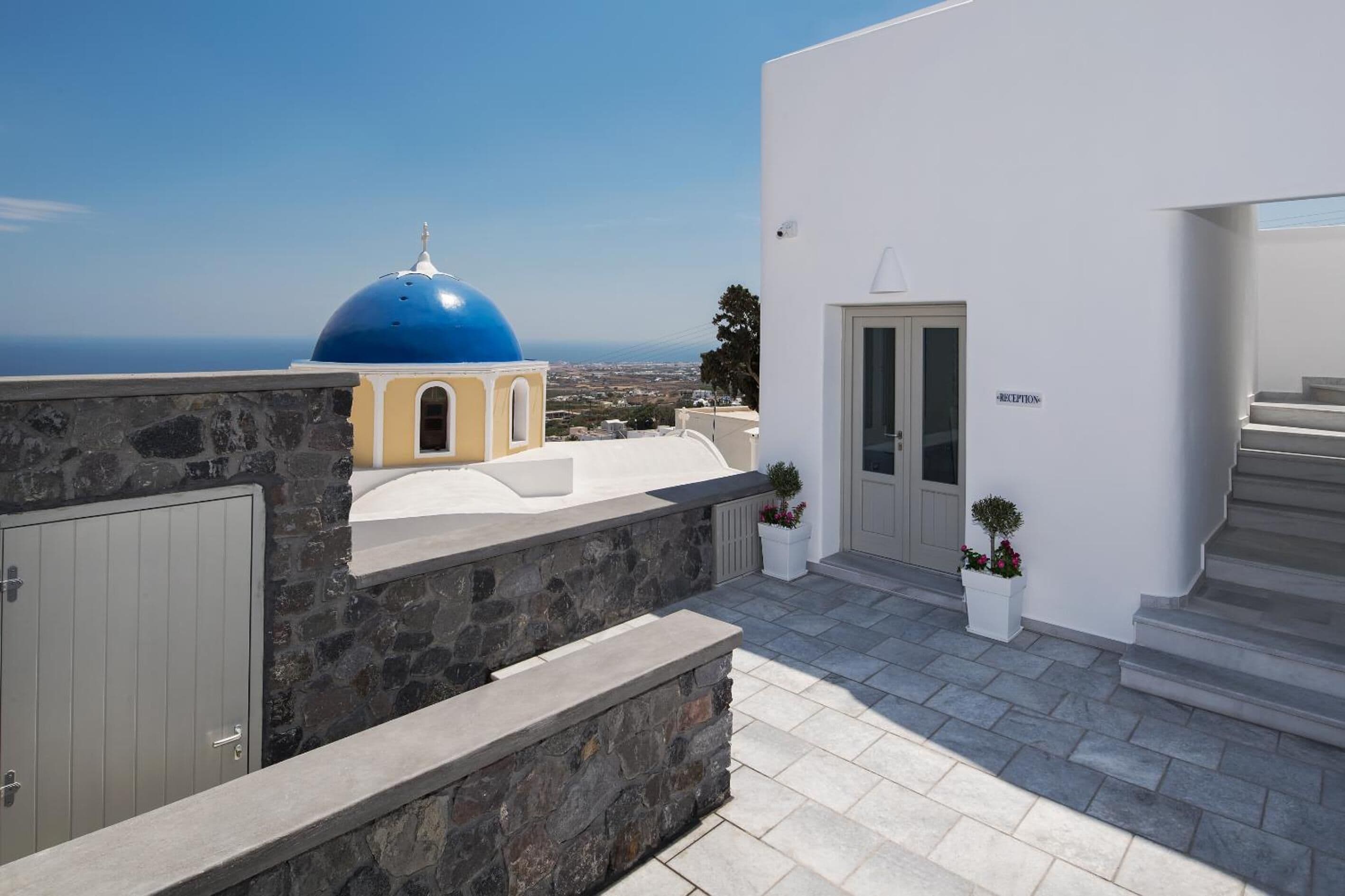 Un edificio moderno con una zona de recepción, paredes de piedra y vistas al mar.