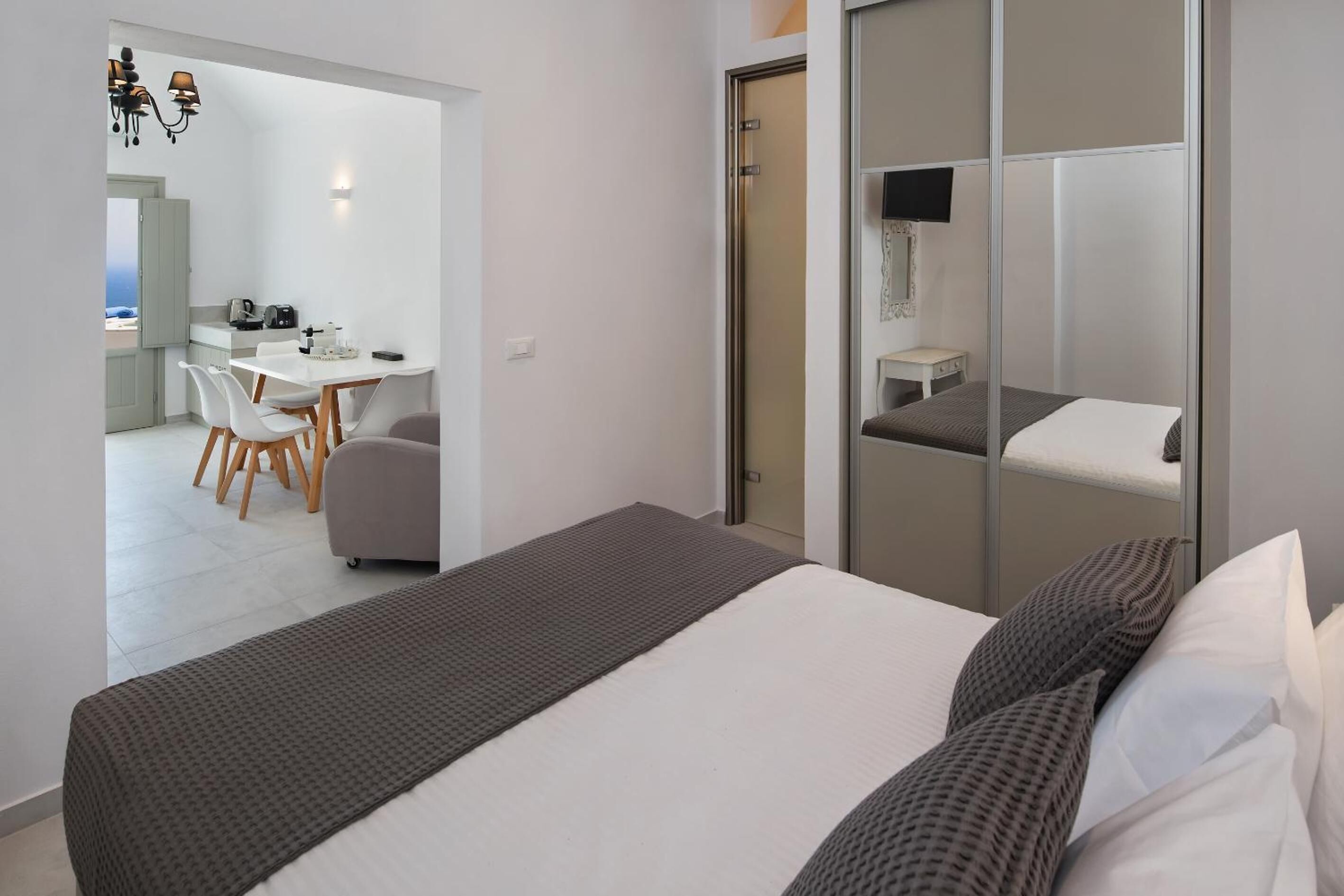A modern hotel room with a large bed, a desk, and a chair.