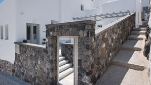 Un bâtiment blanc avec un escalier en pierre menant à une porte.