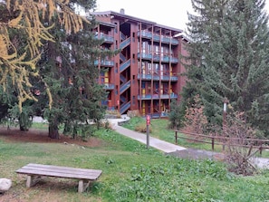 Stunning building with balconies and lush green surroundings.