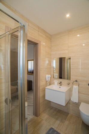 Tina con regadera, secadora de cabello, bidet, toallas 