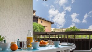 Una mesa dispuesta al aire libre, con vista a un edificio y colinas al fondo.