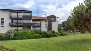 Un moderno edificio de apartamentos con varios balcones y un césped bien cuidado.