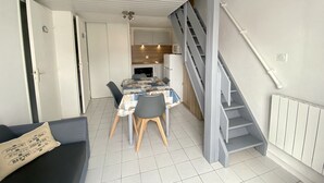 Eine moderne Wohnung mit Essbereich, Küche und einer Treppe.