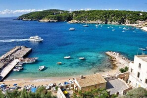 A coastal town with a marina, boats, and a beach.