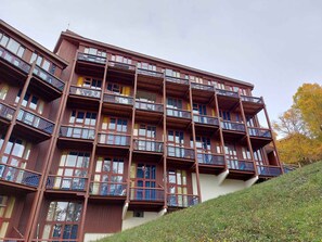 Un hôtel à plusieurs étages, doté de balcons et d’un toit en pente.