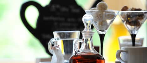 A table with a teapot, a glass pitcher, a cup, and a sugar bowl.