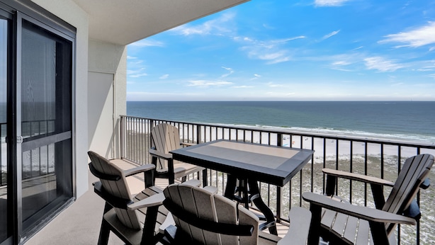 A balcony with a table and chairs overlooking the ocean. - Phoenix VI 1101 by Liquid Life (Orange Beach)