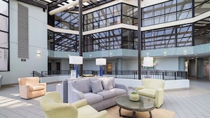 A spacious lobby with a high ceiling, multiple levels, and a central seating area with sofas and armchairs. - Phoenix VI 1101 by Liquid Life (Orange Beach)