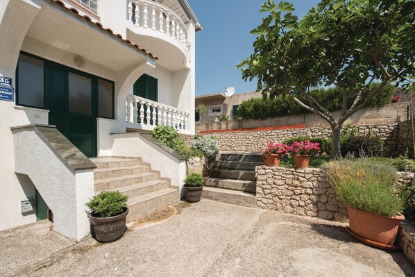 Traditional Mediterranean-style building with a stone entrance and lush greenery.