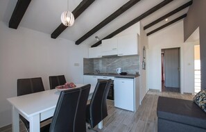 Enjoy meals in the dining area with a white table and black leather chairs.