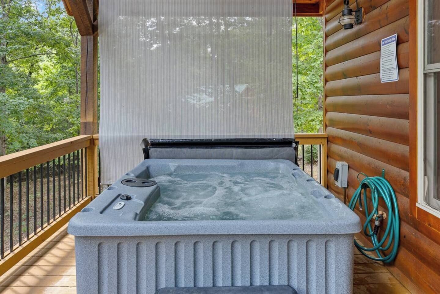 A hot tub on a wooden deck with a view of trees.