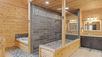 Baño de cabaña de madera con bañera, ducha y tocador de madera.