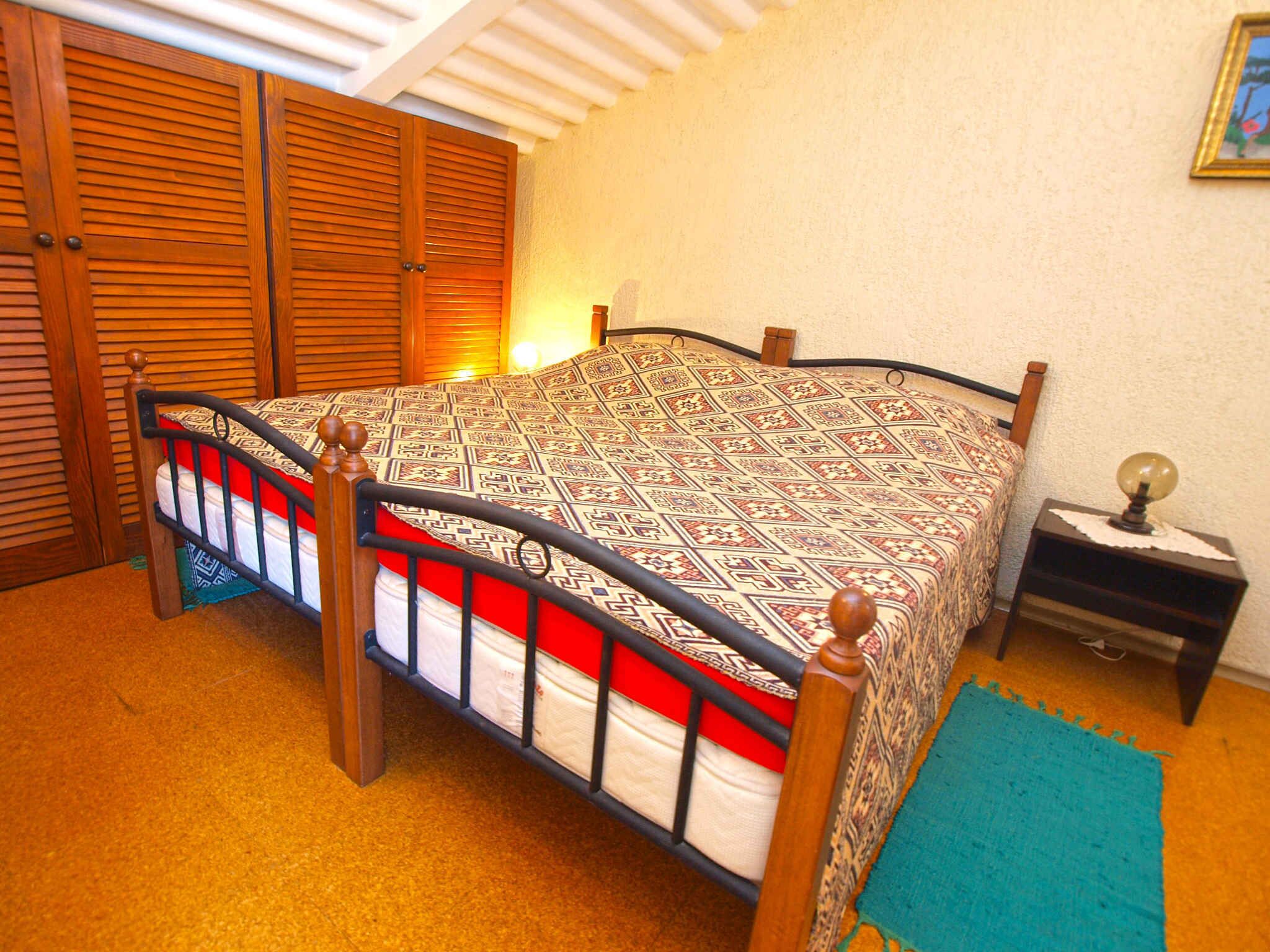 Ein Schlafzimmer mit einem Bett, einem Schrank aus Holz und einem Nachttisch.