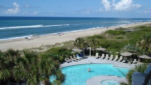 A pool area with a view of the beach and ocean. - Beach Front Condo With Wonderful Ocean View  (Indian Beach)