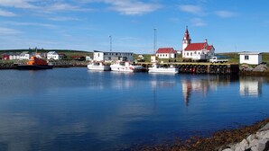 Un port avec des bateaux, une église et des bâtiments le long de la côte.