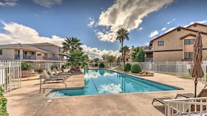 A swimming pool with lounge chairs, a white fence, and houses in the background. - Sports Village Cliffside Getaway/3 bed/2 bath w/View located in St George, UT (St George)