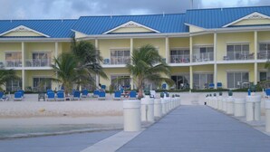 Ein Hotel in Strandlage mit Promenadenweg zum Strand, mehreren Balkonen und Außenbereichen zum Sitzen.