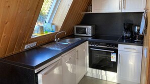 Eine Küche mit Mikrowelle, Herd, Spüle und Schränken.