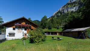 Eine Berglodge mit weißer Fassade, Holzbalkonen und einer Bergkulisse.