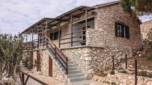 A stone building with a staircase leading to a covered porch. - Stunning home in Kornati with house sea view (Kornati)