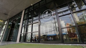 A building with large windows and a sign that reads "The Library Alchemic Bar & Bistro". - Quip Bed & Breakfast (Phuket)