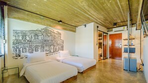 A room with two beds, a wooden ceiling, a mural, and a bathroom door. - Quip Bed & Breakfast (Phuket)