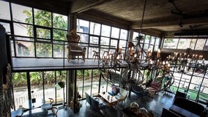 A spacious, modern interior with large windows, a high ceiling, and a variety of seating arrangements. - Quip Bed & Breakfast (Phuket)