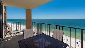 Ein Balkon mit Blick auf Strand und Meer.