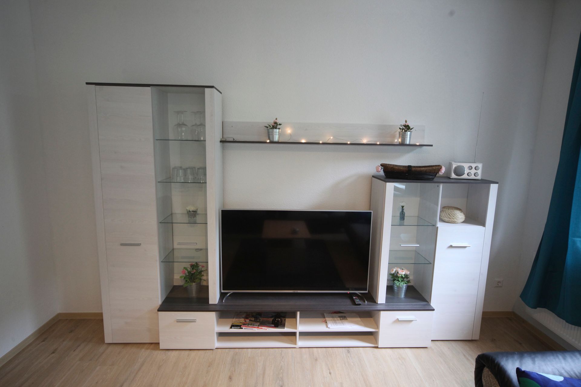 Un salon moderne doté d’un téléviseur à écran plat, d’étagères intégrées et d’une table basse.