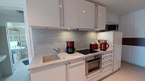 Eine moderne Küche mit Backofen, Kaffeemaschine und Mikrowelle.
