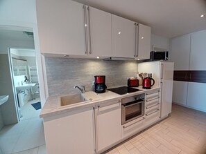 A modern kitchen with a built-in oven, a coffee maker, and a microwave.