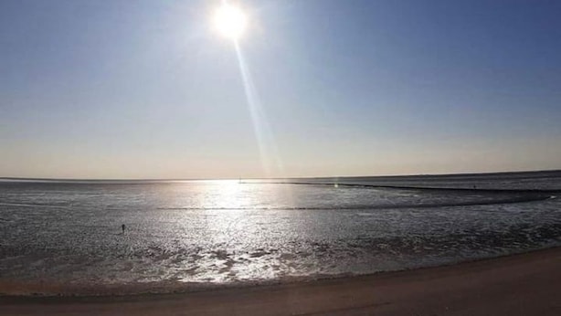 A beach with a clear sky and the sun low on the horizon. - Fewo Nordlichstraße - Fewo Nordlichtstraße (Norden)