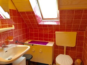 Un baño con lavamanos, inodoro y bañera.