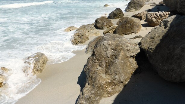 A rocky beach with waves crashing onto the shore.
