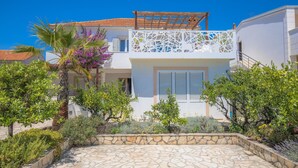 A two-story building with a balcony, stone pathway, and surrounding greenery. - 3 bedroom awesome apartment in Rogoznica (Rogoznica)