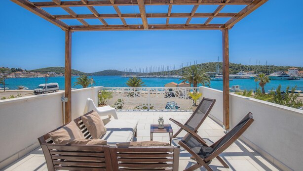 A balcony with wooden furniture, a view of the sea, and a clear sky. - 3 bedroom awesome apartment in Rogoznica (Rogoznica)