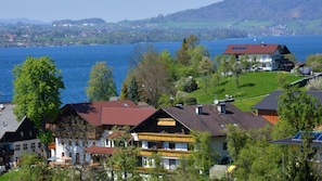 Un pueblo a orillas del lago con casas tradicionales, vista al lago y un pueblo distante.