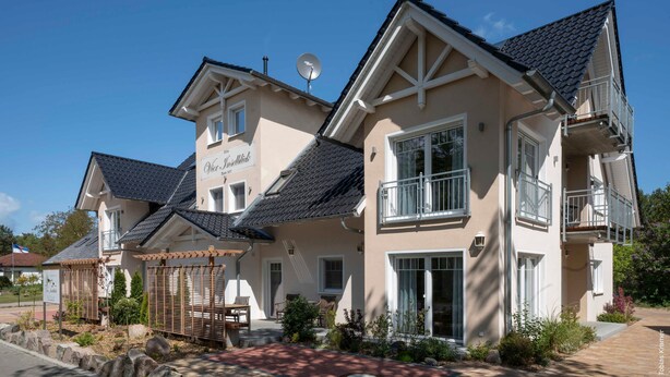 Kaksikerroksinen talo, jossa on parveke, satelliittiantenni ja kyltti, jossa lukee: »Château de la Forêt».