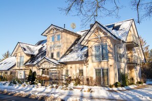 A multi-story house with a snow-covered roof, satellite dish, and a balcony. - Apartment Ruden - Villa Vier Inselblick (Kröslin OT Freest)