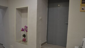 A hotel room with a large mirror, a door, and a coffee machine on a counter. - Bassetto 013 (Naples)