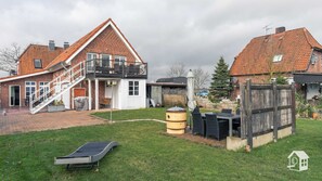 Il s’agit d’une propriété résidentielle comprenant une maison à deux étages en briques, un patio couvert et un petit espace extérieur aménagé avec une table et des chaises.