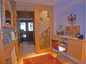 A wooden interior with a desk, chair, and a decorative wall piece.