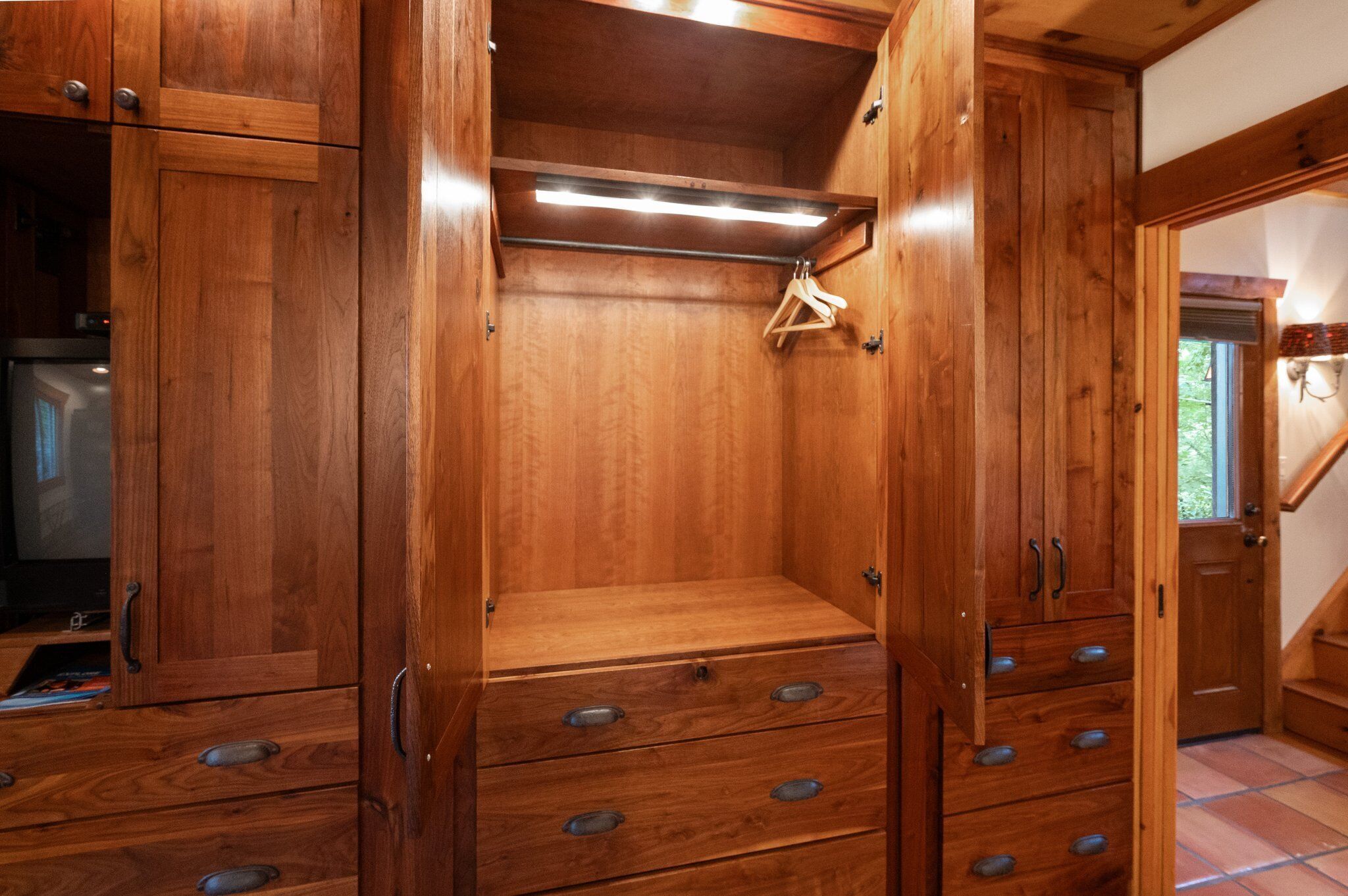 Un armario de madera con varios cajones y espacio para colgar ropa.